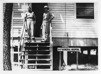 Two men standing on wooden steps of building with sign: 64th GENERAL HOSPITAL