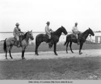 A.L. Gayle, T.L. Freeman and Dr. R.P. Howell ride horses near the river in the 1940s